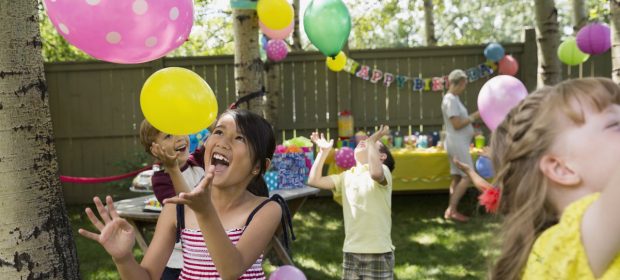 A little girl that is holding a balls